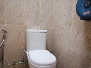 新加坡斯拜斯博德@卡姆旅舍的浴室设有白色的卫生间和石墙