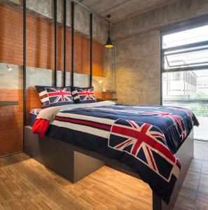 清迈清迈斯特普旅馆的一间卧室配有一张特大号床和英国国旗枕头