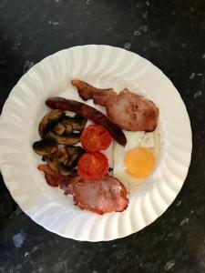 Dersingham圣裘德住宿加早餐旅馆的包括香肠和鸡蛋的早餐纸盘