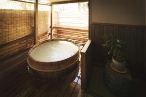 藏王温泉高宫米亚玛索日式旅馆的植物间里的一个大型木浴缸