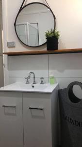 CapelCapel Short-Stay Accommodation的浴室设有水槽和架子上的镜子