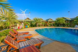 班佩环松塔里度假村的一个带两把椅子和风车的游泳池