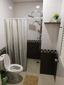 合艾合艾T.M.之家旅馆的浴室配有白色卫生间和淋浴。