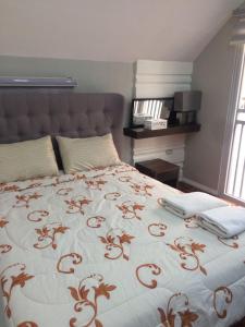 安吉利斯希拉里缇莫戈公园别墅的一间卧室配有一张带红白毯子的床