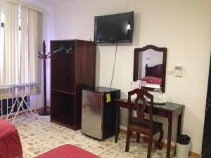 MacuspanaHotel Claudia的客厅配有书桌、镜子和电视