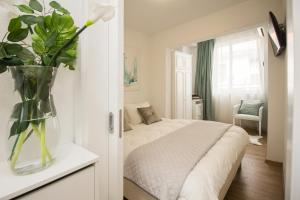 马卡尔斯卡Apartmani Leo-Marin的一间卧室,配有一张带花瓶的床