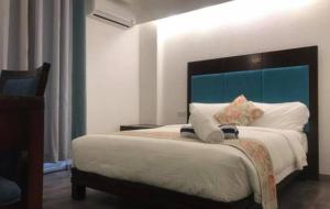 长滩岛长滩岛埃尔普尔托酒店的一间卧室配有一张大床和蓝色床头板