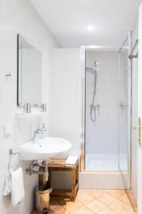 图尔恩尼北仑葛湖富酒店的白色的浴室设有水槽和淋浴。