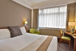艾纯查姆曼彻斯特-奥特林厄姆-克雷斯塔-贝斯特韦斯特酒店的配有一张床、一张书桌和一扇窗户的酒店客房