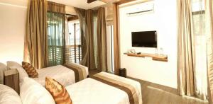 波尔多·格尼拉无限度假村的酒店客房设有两张床和电视。