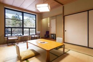 日光清晃苑日式旅馆的客房设有桌椅和大窗户。