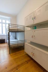 蒙特卡罗埃斯托里尔Change The World Hostels - Cascais - Estoril的一间卧室设有两张双层床,铺有木地板。