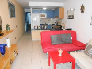 普拉亚布兰卡Las Moreras Apartment 135的客厅配有红色沙发和红色桌子