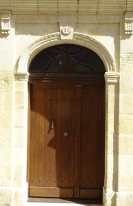 圣艾米隆12 Rue des Ecoles的石砌建筑中木门与拱门