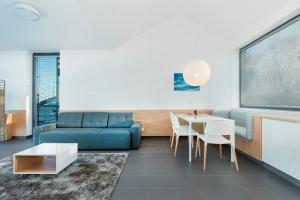 尤斯托尼莫斯基Apartamenty Laguna Boulevard by Renters Prestige的客厅配有蓝色的沙发和桌子