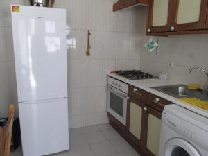 卡武埃鲁Apartamento na Praia的厨房配有白色冰箱和水槽