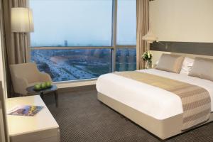 埃尔比勒Erbil Arjaan by Rotana的酒店客房设有一张床和一个大窗户