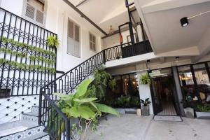 万象布鲁姆精品酒店及咖啡厅的前面有楼梯和植物的建筑