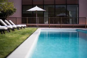 波亚克城堡考尔德宜兰-巴盖尔斯酒店的一个带椅子和遮阳伞的游泳池