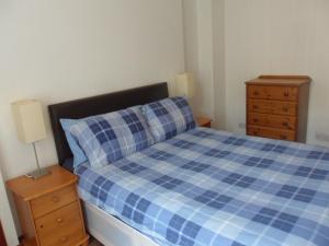 格拉斯哥The Exeter的卧室配有蓝色和白色的格子床