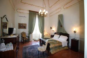 SquinzanoPalazzo De Castro的一间卧室配有一张床和一个吊灯