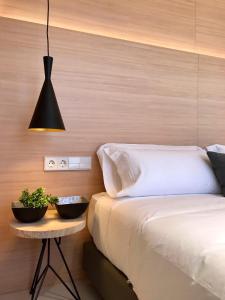 毕尔巴鄂Inside Bilbao Apartments的一间卧室配有一张床和一张植物桌子