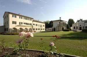 卡多格尼托德里尼别墅酒店的一座白色的大建筑,有鲜花庭院