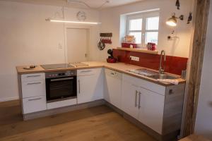 维林根Wilkenhof的厨房配有白色橱柜和水槽