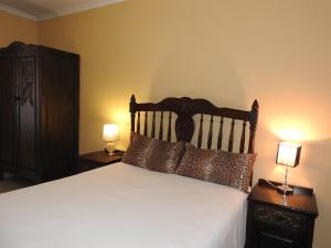 阿曼济姆托蒂沙龙玫瑰旅馆的一间卧室配有一张带2个床头柜和2盏灯的床。