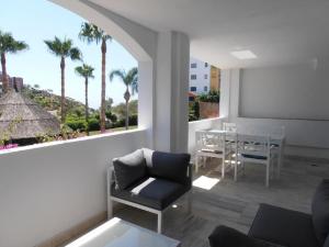 阿尔姆尼卡Balandro Apartment的客厅配有椅子和桌子,并种植了棕榈树