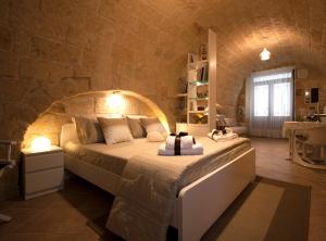 特拉尼dormiRÈtrani的卧室配有一张石墙内的大床