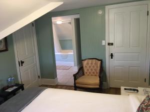 钱伯斯堡拉各德艾治旅馆的一间卧室配有一张床和一把椅子,还有一间浴室