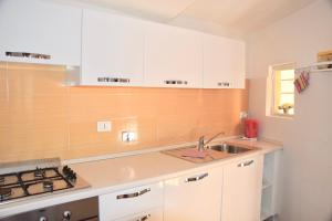 罗马库尔罗马公寓的厨房配有白色橱柜和水槽