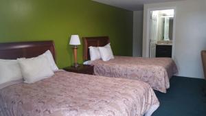 Mount Holly霍利山斯林百兰汽车旅馆的绿墙旅馆客房的两张床