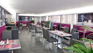 蒙彼利埃Privilège Hôtel & Apparts Eurociel Centre Comédie的餐厅设有桌椅和紫色墙壁