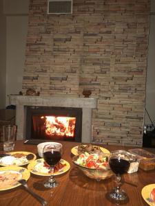 潘波洛沃Apt ECE PAMPOROVO的餐桌、食品和酒杯以及壁炉