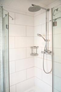 布利斯卡斯特尔Ferienunterkunft Heidi的浴室铺有白色瓷砖,设有淋浴。