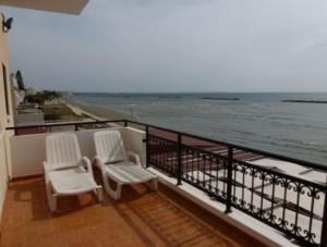 拉纳卡Philippou Beach Villas & Apartments的两把白色椅子坐在一个海景阳台上