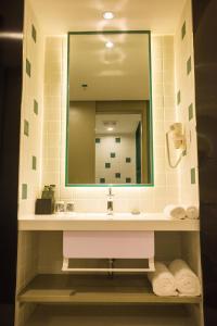 阳朔白玉兰阳朔西街酒店的浴室配有盥洗盆、镜子和毛巾
