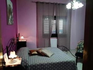 Sogliano CavourCasa Rosa的一间卧室配有一张床和一张带两盏灯的桌子。