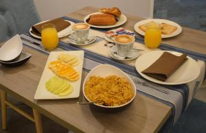 桑亨霍Hotel Rural Seixalvo的餐桌上摆放着早餐食品和橙汁盘