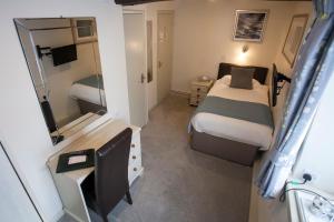 Moulton白杨酒店的一间小卧室,配有一张床和镜子