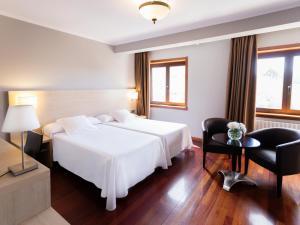 费罗尔瓦伦西亚酒店的酒店客房设有一张白色大床和椅子