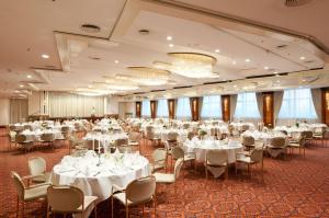 马格德堡玛丽蒂姆马格德堡酒店的一个带白色桌椅的大型宴会厅