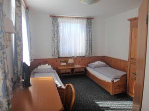 林道灵多尔巴登海景酒店的客房设有两张床、一张桌子和一个窗户。