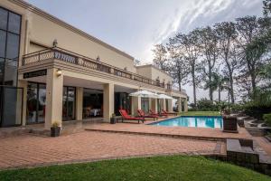 巴利托Ebandla Hotel & Conference Centre的一座带游泳池和一些椅子的房子