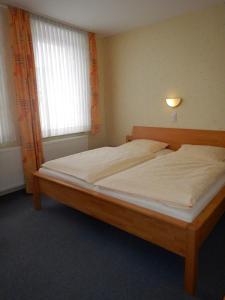 霍恩-巴特迈恩贝格Havergoh Wander- & Fahrrad-Hotel的一间卧室配有一张带白色床单的木床