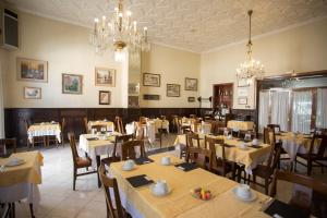 特伦普二十世纪酒店的一间带桌椅和吊灯的餐厅