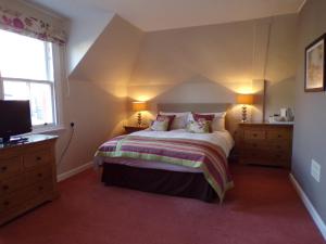 邓迪Shaftesbury Hotel Dundee的一间卧室配有一张大床、两个床头柜和电视