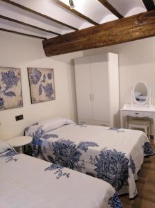 贝洛拉多Hotel La Huella Del Camino的配有白色墙壁和木制天花板的客房内的两张床
